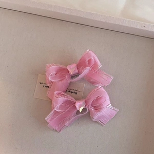 Detalle de pinzas para el pelo con lazo de malla rosa, lentejuelas de corazón y cinta