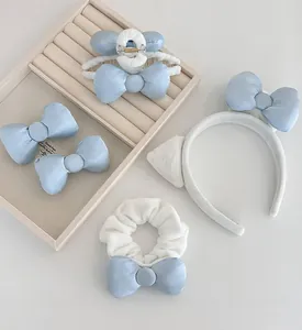 Detailansicht von hellblau-weißen Schleifen-Haaraccessoires mit Haarbändern und Clips