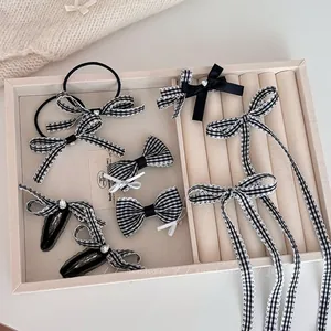 Close-up of black and white checkered bow hair clips with rhinestones and pearls