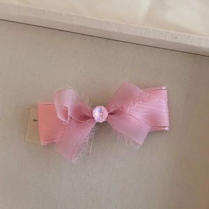 Primer plano del clip para el pelo con lazo rosa y gema central facetada brillante