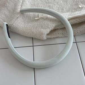 Detail of mint green padded sponge headband with handmade label and twill fabric
