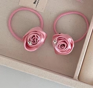 Detalle de un coletero de rosa de satén rosa con un cristal brillante en caja