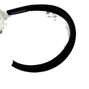 Handmade black sponge headband with textured satin fabric and internal logo detail