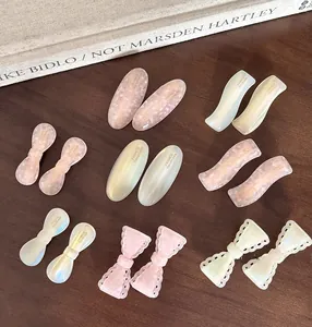 Detailed set of macaron pink and cream white acetate hair clips on a vintage wooden desk