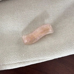 Detail of pink marble acetate wave hair clip with France Handmade gold lettering