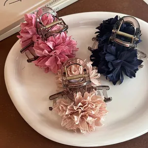 Detailansicht von drei eleganten Stoffblumen-Haarklammern in Rosa, Marineblau und Champagner