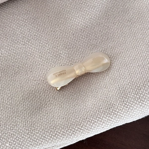 Close-up of pink acetate hair clip with gold metal clasp and France Handmade lettering