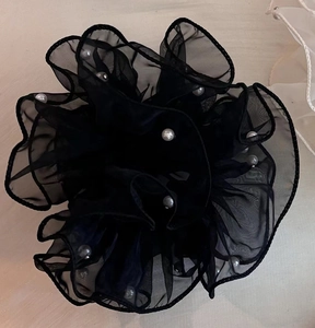 Gros plan sur un chouchou en organza noir avec perles blanches et maille plissée