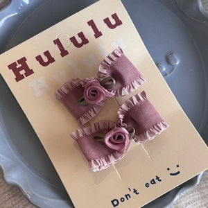 Détail de barrettes à nœuds roses avec roses en tissu 3D sur un plateau décoratif