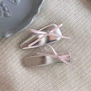 Set de barrettes en cuir argenté avec rubans roses sur texture tricotée douce