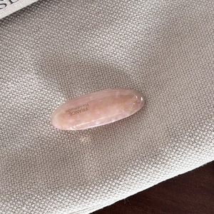 Close-up of a pink marble acetate hair barrette with France Handmade engraving detail