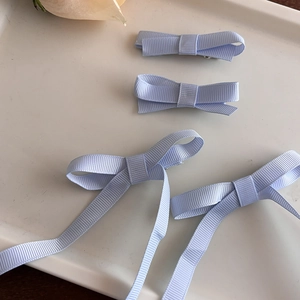 Lot de quatre barrettes à cheveux avec nœuds bleu clair et rubans sur plateau