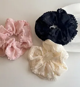 Vue détaillée de chouchous en dentelle avec broderie fine et bords festonnés élégants