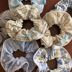 Dettaglio di elastici scrunchie blu stile balletto con motivi a quadri, righe e fiori