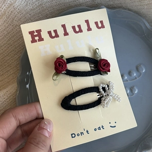 Détail de barrettes à cheveux rose douce et nœud en perles sur carte de présentation