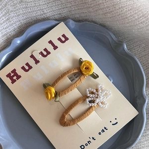 Détail de pinces à cheveux à fleurs roses et perles sur une assiette de présentation