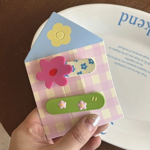 Détail de pinces à cheveux fleuries mignonnes incluant fleur rose et barrette verte