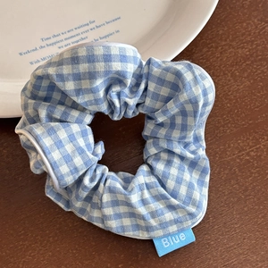 Dettaglio di un elastico per capelli stile balletto a scacchi blu e bianchi