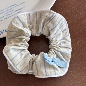 Primo piano di un elastico per capelli a righe blu e bianche con un fiocco