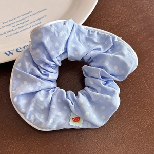 Dettaglio scrunchie celeste a pois con ricamo di anguria e bordo con profili bianchi