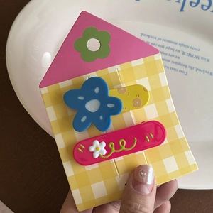Détail de barrettes mignonnes d'ours et de lapin avec motifs floraux sur carte à carreaux