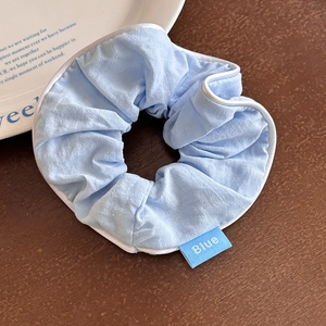 Dettaglio dell'elastico azzurro con bordi bianchi e etichetta tessuta Blue