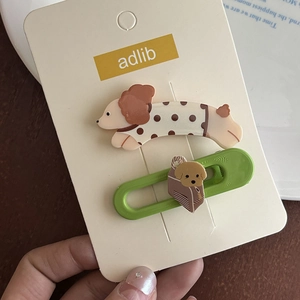 Gros plan de pinces à cheveux chiot vert et caniche dessin animé sur carte