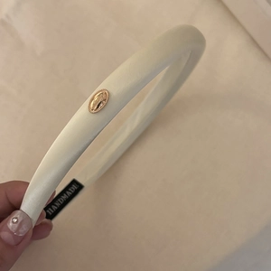 Elegant ivory satin padded headband with a golden metal buckle and handmade label