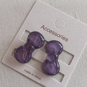 Close-up of purple transparent bow hair clips on a white display card for kids