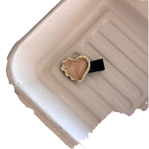 Minimalistische Haarspange in Herzform mit aprikosenfarbenem Inlay und Goldrand-Struktur