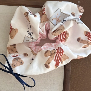Detail of scrunchie with teddy bear print, plaid lining and blue ribbon bow