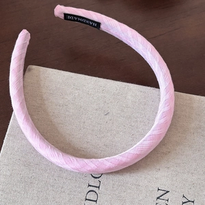 Pink checkered sponge headband with twill texture and handmade woven label detail