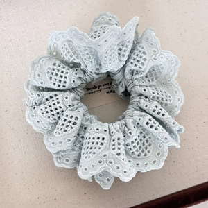Handmade light blue lace scrunchie with intricate embroidery and elegant wavy edges