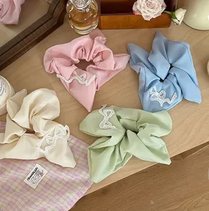 Close-up of chiffon bow scrunchies in pastel colors with delicate lace embroidery detail