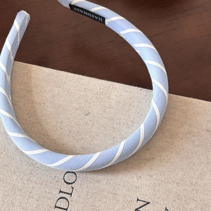 Detailed macro view of the sky blue twill fabric headband and handmade inner label