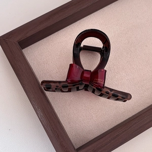 Close-up of tortoise shell hair claw clip with a red France Handmade bow detail