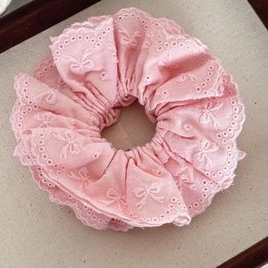 Detailed embroidery on light pink lace scrunchie with delicate butterfly patterns