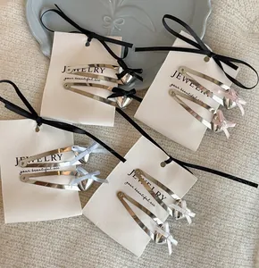 Close-up of heart-shaped metal hair clips with colorful ribbon bows on cards