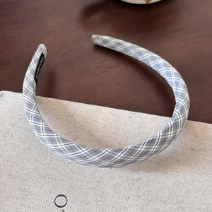Close-up of handmade gray plaid fabric headband featuring a woven HANDMADE label inside