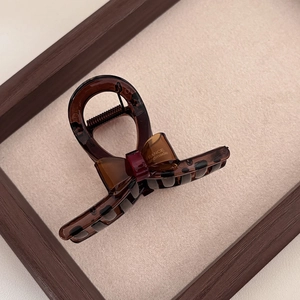 Detail of tortoiseshell bow hair claw with France Handmade text on vintage wood base
