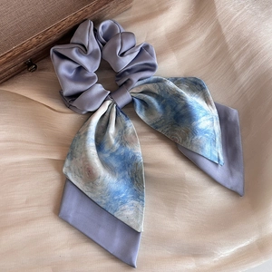 Detailed macro view of the silky lilac purple Monet lily print scrunchie with streamers