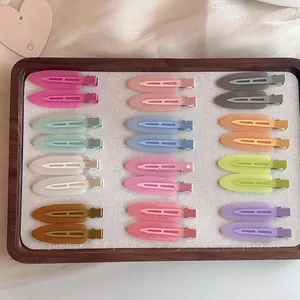 Set of colorful matte duckbill hair clips in various macaron colors on a wooden tray