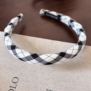 Classic black and white checkered fabric thin headband with a handmade label on wood
