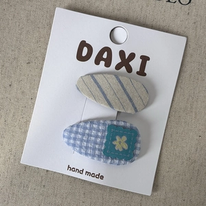 Detail of blue plaid and striped handmade fabric BB hair clips on display card
