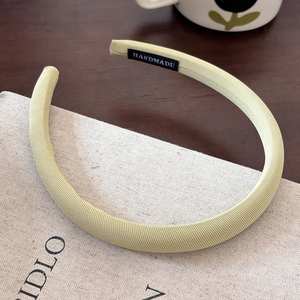 Detail of light green twill fabric headband with handmade label and ribbed texture