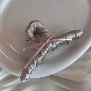 Close-up of champagne satin hair claw clip with a delicate pink ribbon bow detail