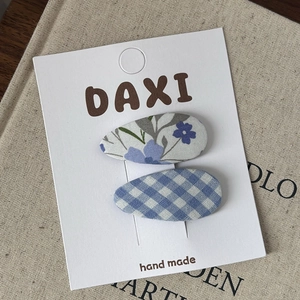 Two-piece set of blue floral and checkered fabric BB hair clips on a display card