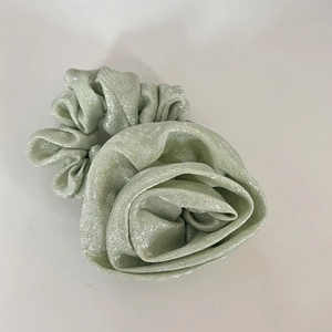 Pale green scrunchie with large metallic floral decoration for elegant ponytails