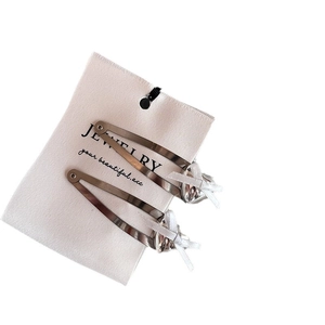 Set of two silver heart BB clips with white ribbon bows on a jewelry display card