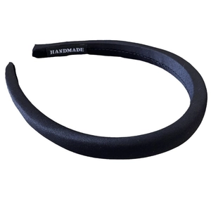 Chic black satin padded headband with handmade label on white background for women